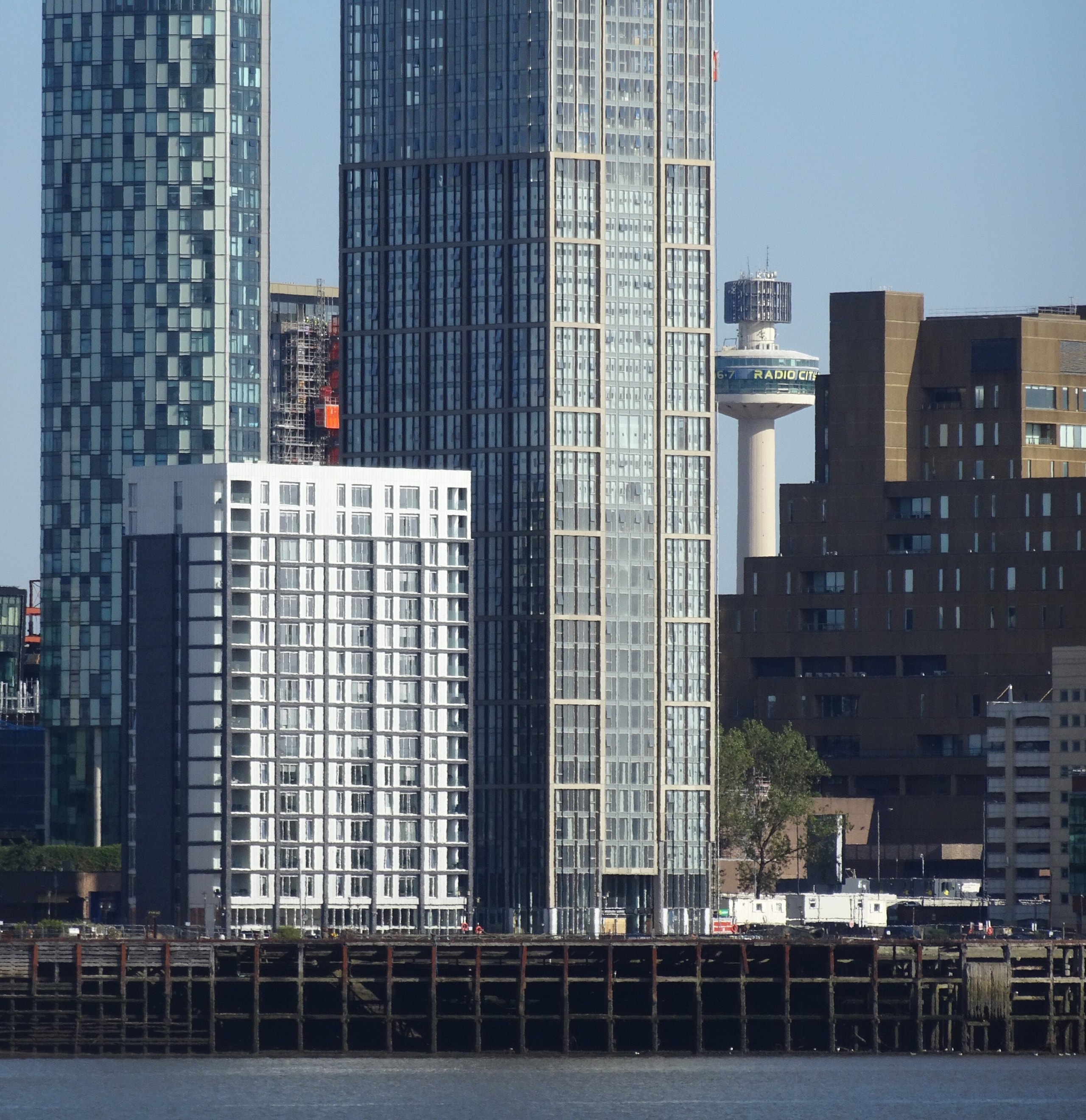 The Lexington, a tall glass tower on Liverpool's waterfront, seen across the Mersey beside the Radio City tower