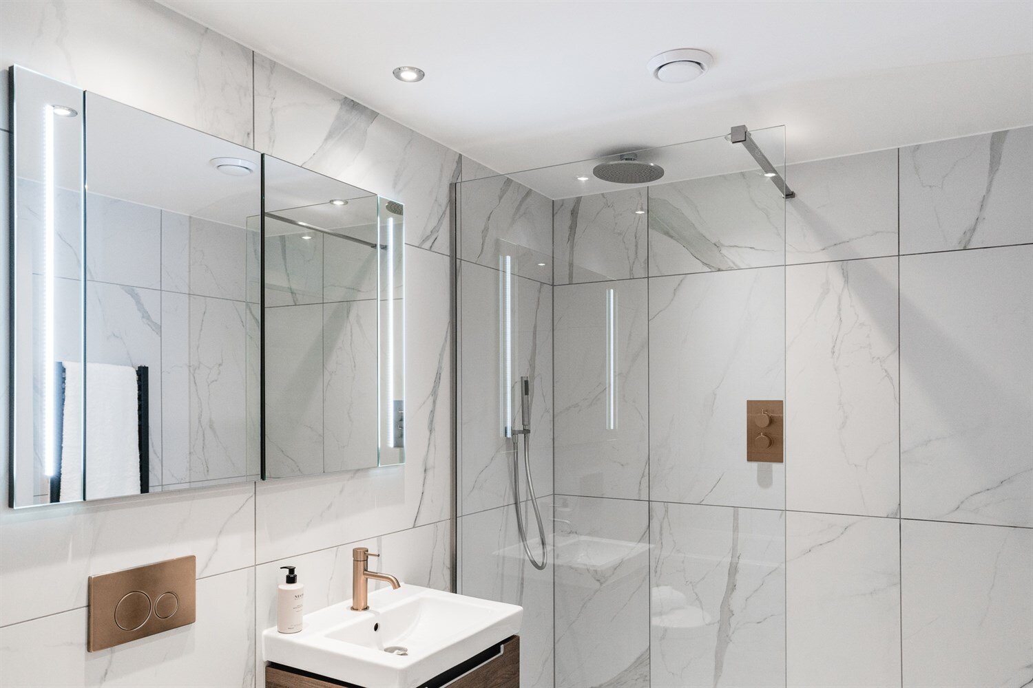 Shower room with a rain shower, marble-effect tiles and bronze fittings
