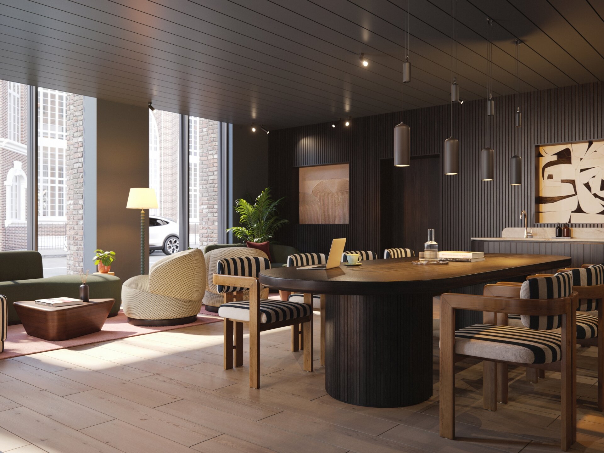Co-working lounge with a long work table, soft seating and pendant lights