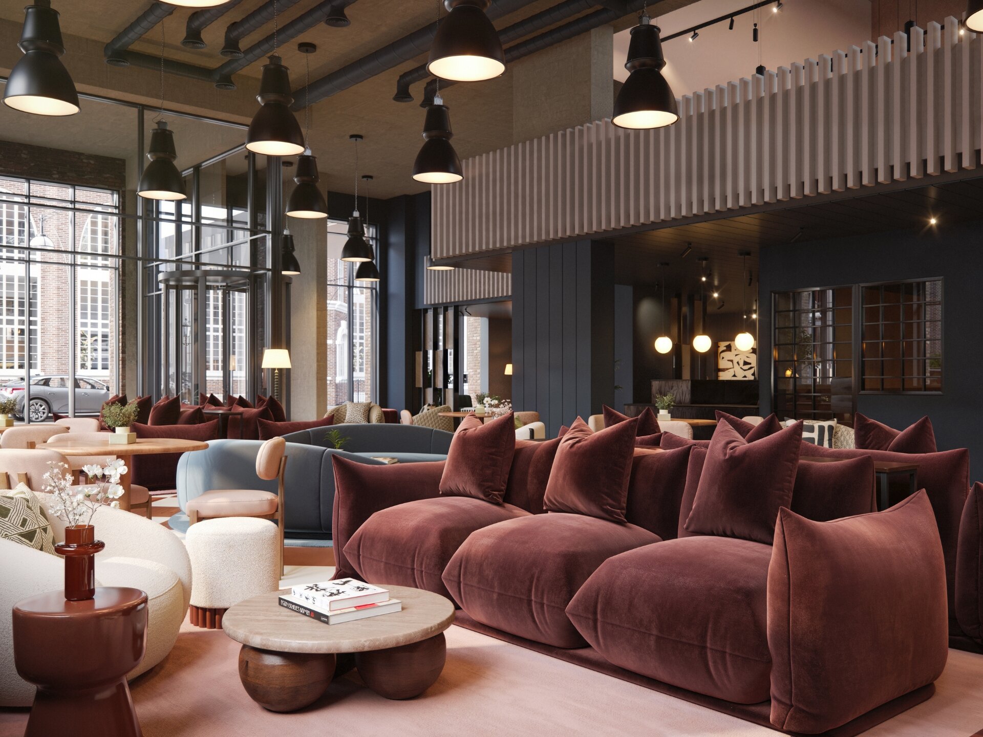 Residents' lounge with plush velvet sofas beneath industrial pendant lights