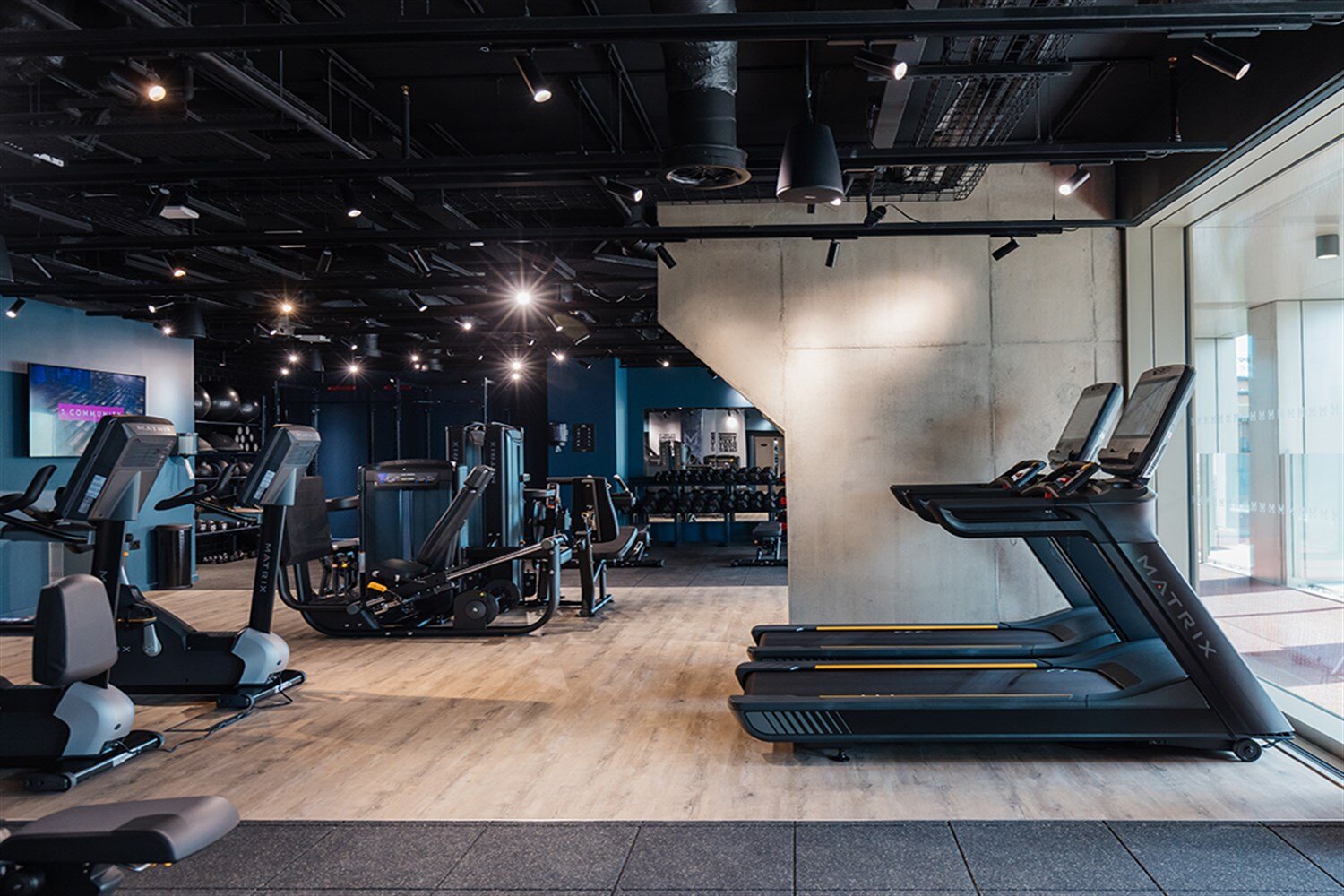 Residents' gym with treadmills and cross-trainers beneath an industrial ceiling, at The Mercian, Birmingham