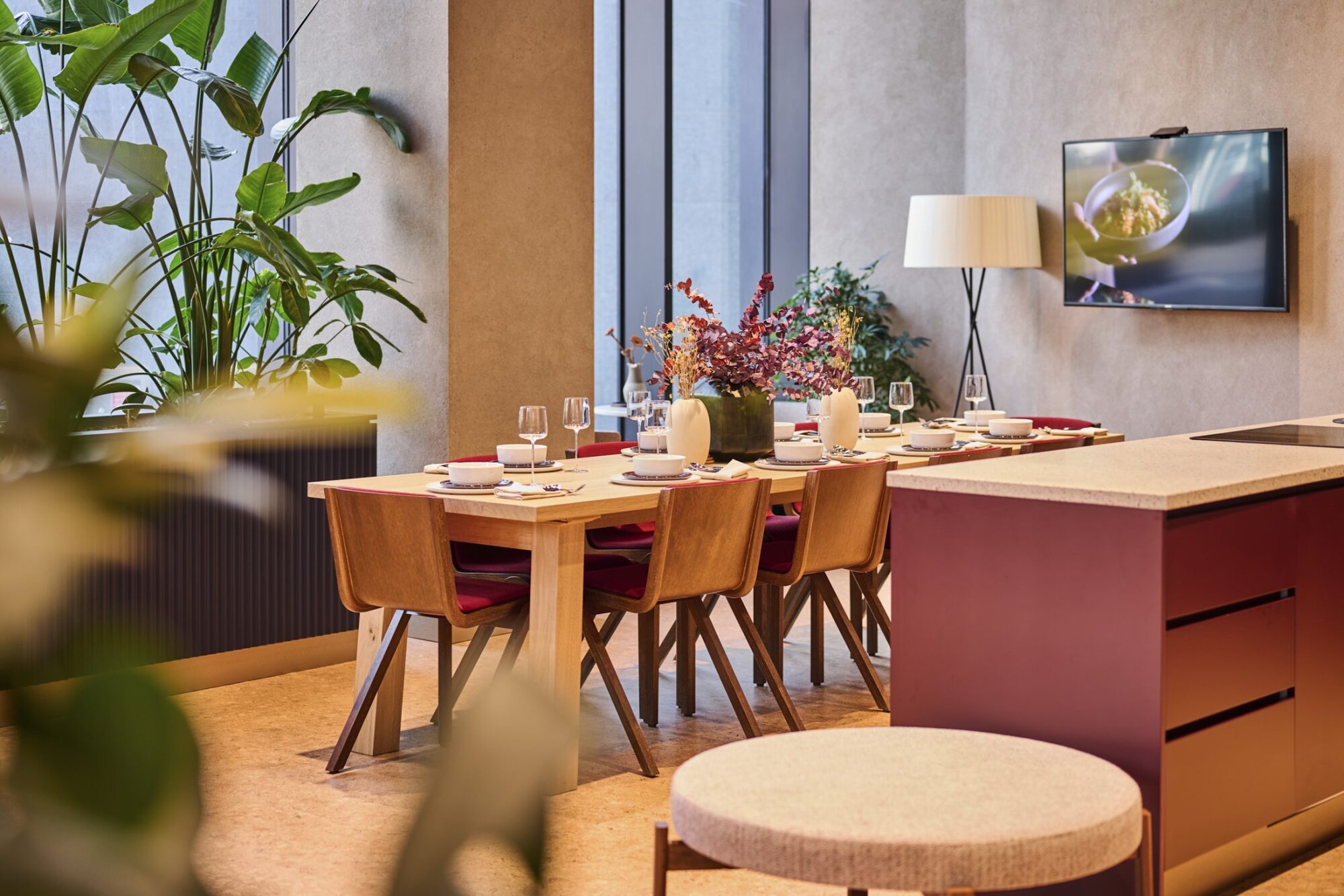 Private dining room with a table laid for eight, a kitchen island and lush plants, at The Octagon, Birmingham