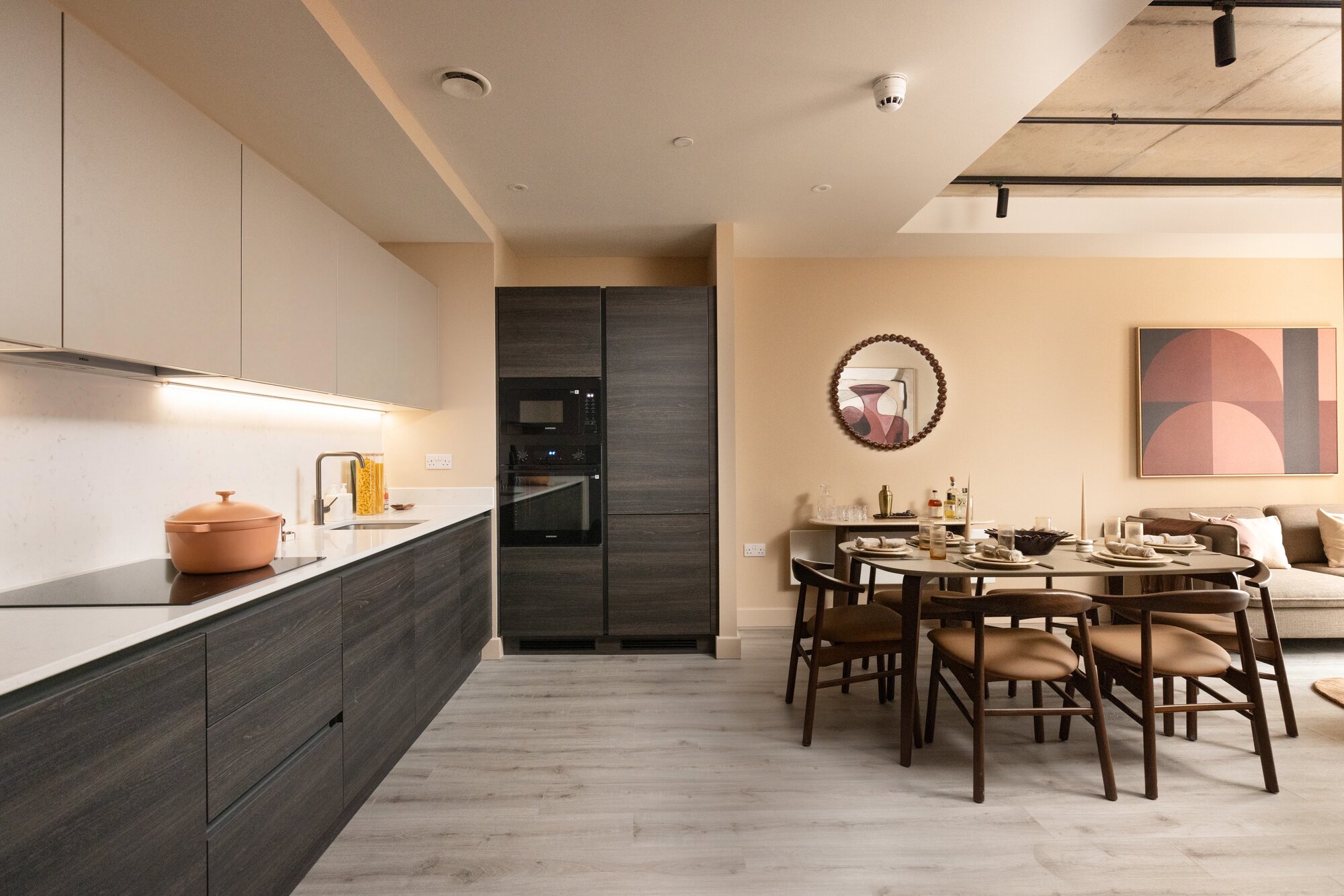 Long kitchen opening onto a dining table laid for six