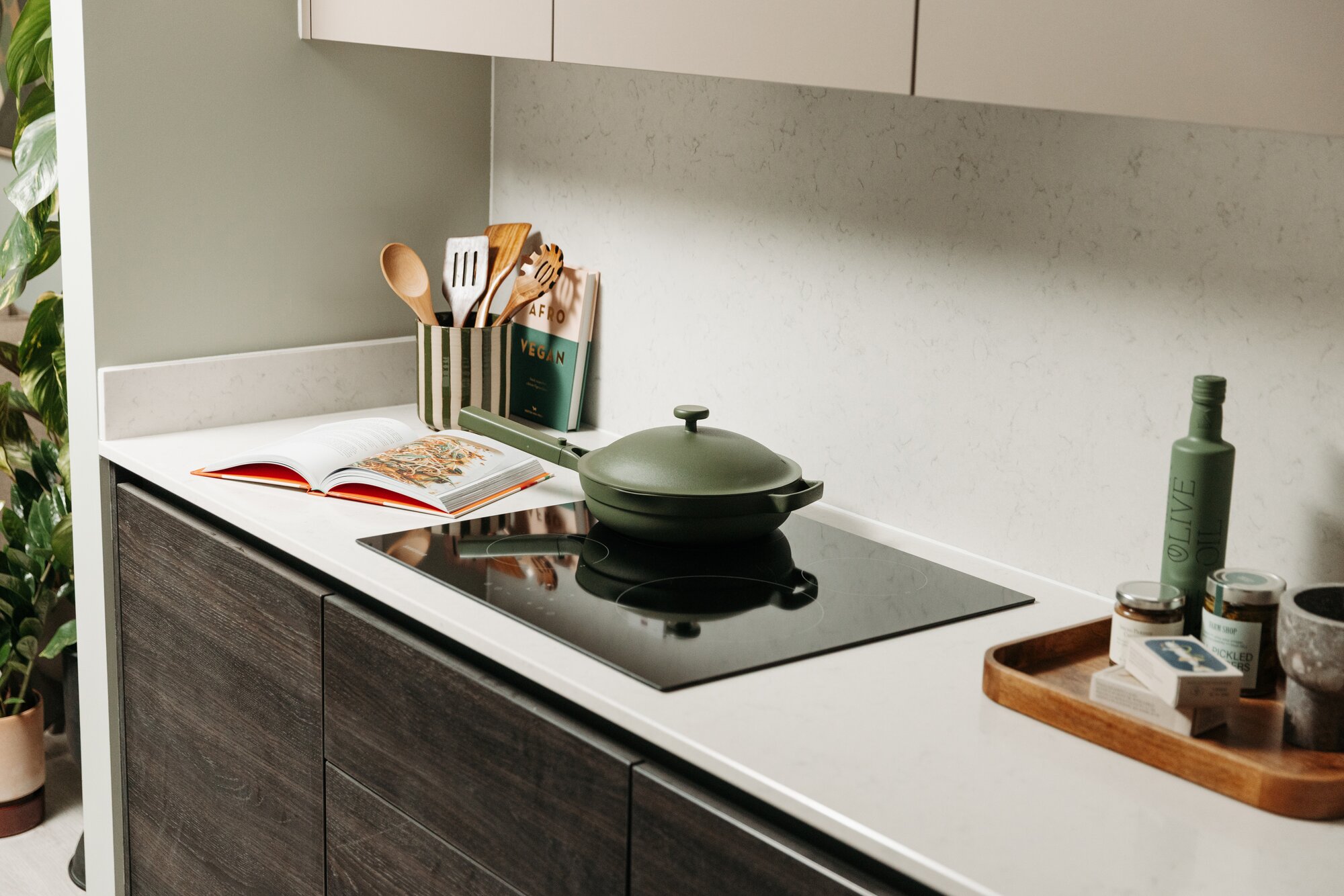 Induction hob with a green cast-iron pot and an open cookbook